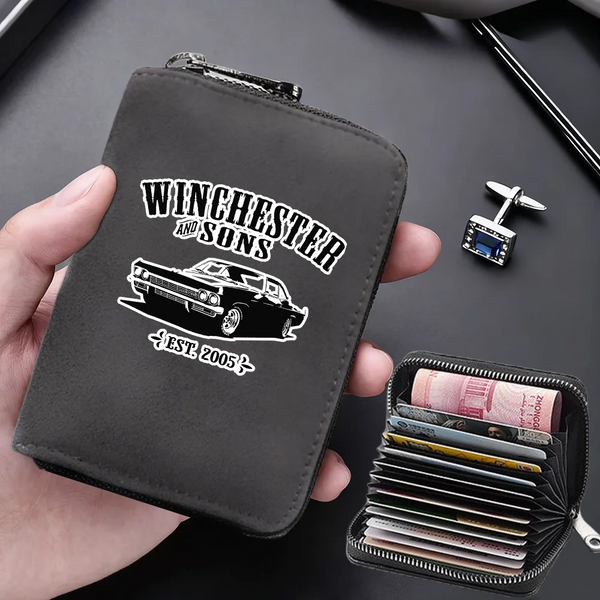 A dark gray leather card wallet with a silver clasp and a separate black card holder is shown being held by a hand.