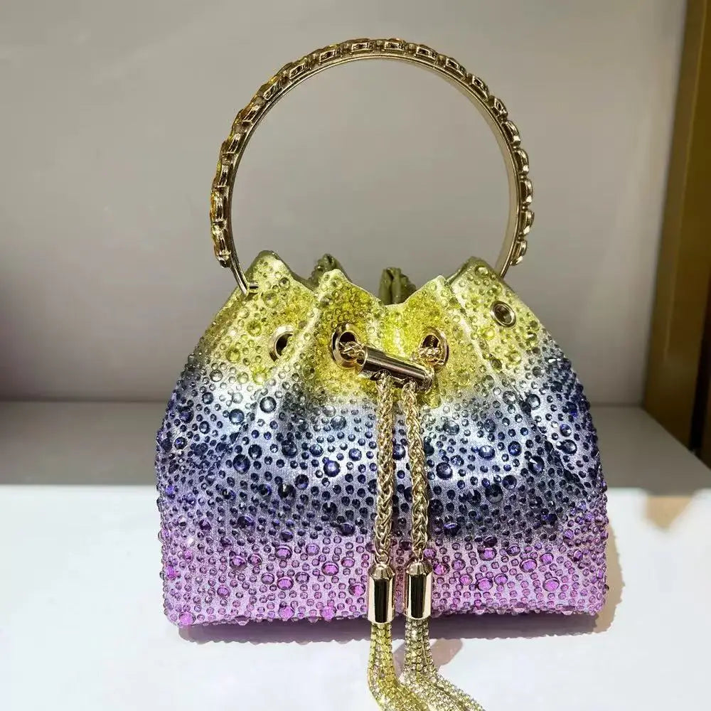 A sparkling purple and gold crystal-embellished evening clutch with a gold chain handle.