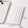 A white crocodile pattern slim card holder wallet next to a smartphone.