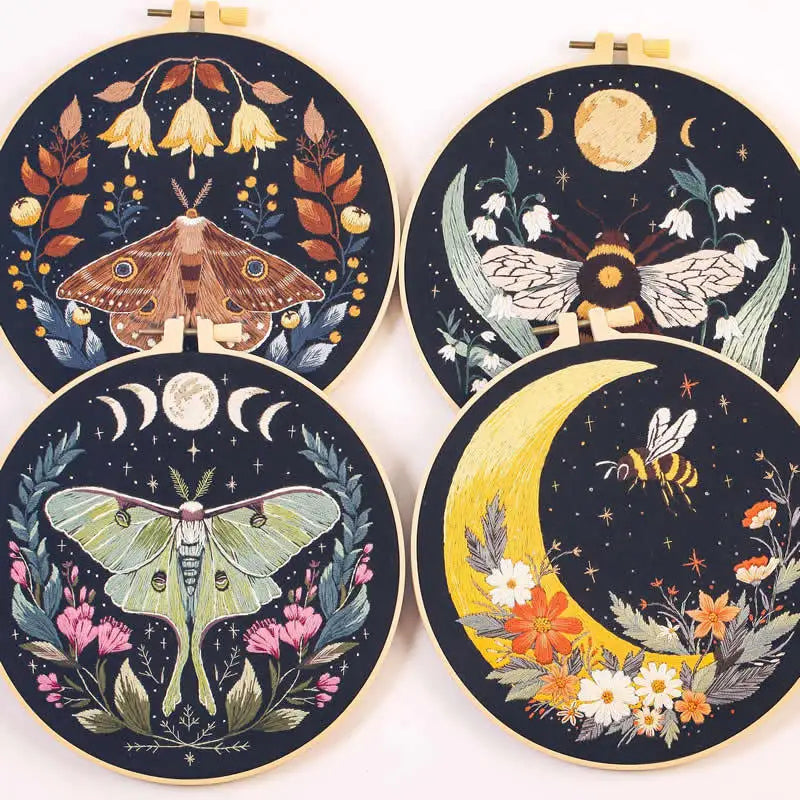 A set of four circular embroidery kits featuring detailed butterfly and moon designs on dark fabric.