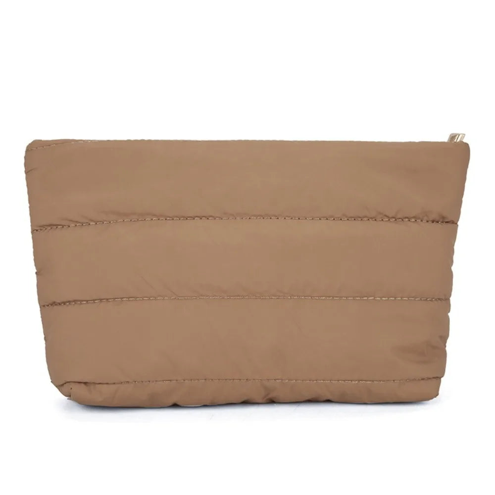 A tan quilted cosmetic travel bag with a zipper closure.