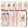 A set of customizable stainless steel nail clippers and tools in a light beige case with initial letters and name personaliza