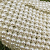 A close-up of a clutch bag covered entirely in small, round white pearls.