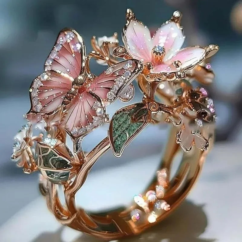 Gold-toned aesthetic flower and butterfly rings featuring pink and green floral designs