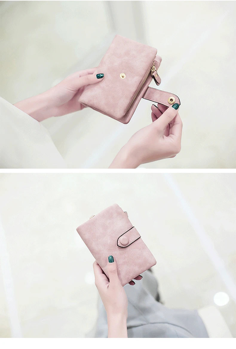 A hand holds a pink frosted card wallet with gold hardware and an emerald green accent.