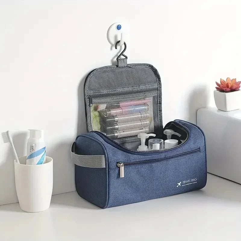A navy blue durable hanging leather toiletry bag with a lid and a hanging loop is displayed on a white surface.