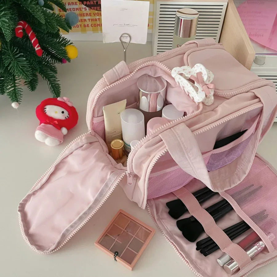 Pinkes Luxus-Portemonnaie für Make-up, geöffnet mit verschiedenen Fächern und Pinseln.