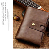 Braunes Leder-Bifold-Wallet liegt auf Holzoberfläche neben einem Gitarrenhals.