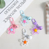 A collection of colorful resin flower keychains in pink, blue, and purple hanging from rings.