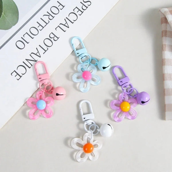 A collection of colorful resin flower keychains in pink, blue, and purple hanging from rings.