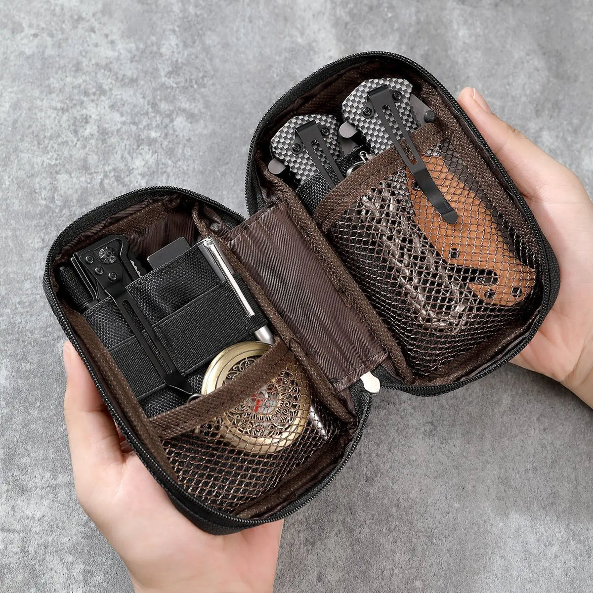 A hand holds an open dark brown organizer pouch for multi-tools and outdoor gear.