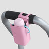 A pink silicone cup holder is mounted on a gray bicycle handlebar.