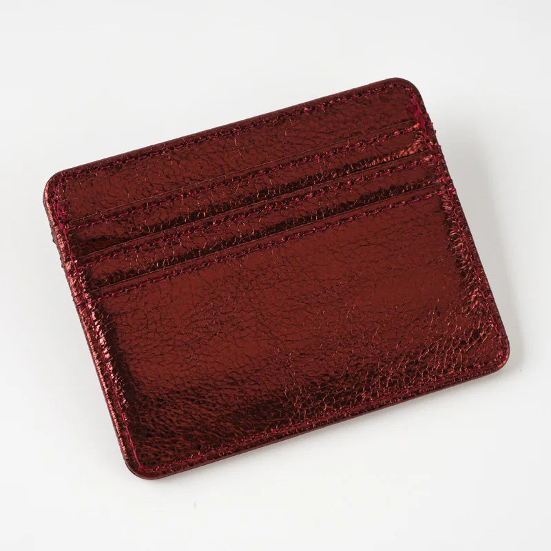 A rectangular, reddish-brown faux leather card holder with embossed lines.