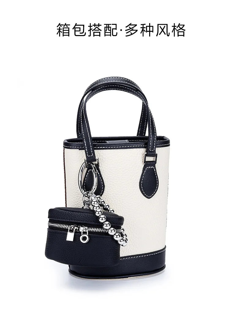 A handcrafted leather neck pendant coin purse with a black lanyard and a white and black striped bag.