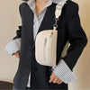 A woman wearing a black blazer and striped shirt holds a cream PU leather multi-pocket crossbody bag.