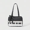 A black tote bag with white polka dots featuring a piano lace trim and a bow detail.