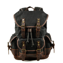 A dark brown canvas hiking backpack with leather accents and brass buckles.
