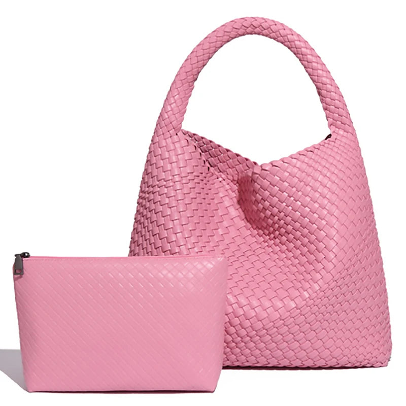 A pink handwoven faux leather tote bag and matching clutch displayed together.