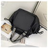 A black nylon shoulder bag with a square compartment and patterned fabric trim is shown on a white surface.