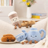 A collection of soft, adorable cartoon character plush toys in various colors and shapes resting on a white surface.