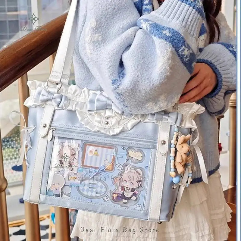 A light blue and white knitted sweater sleeve holds a transparent shoulder tote bag decorated with floral and vintage element