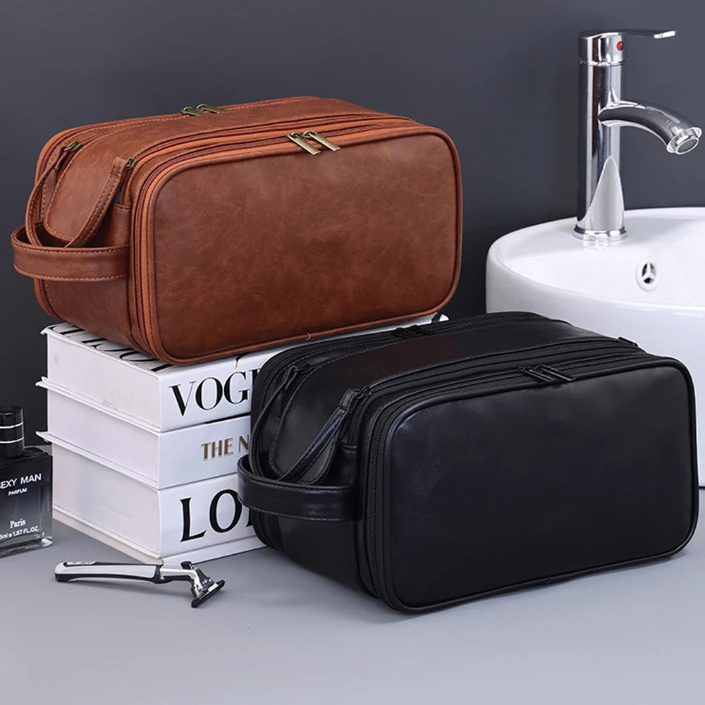 Un sac à toilette en cuir marron et une valise en cuir noir sont exposés à côté d'un lavabo et d'un robinet blancs.