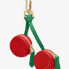 A red cherry fruit shape coin purse keychain with gold hardware and green fabric strap.