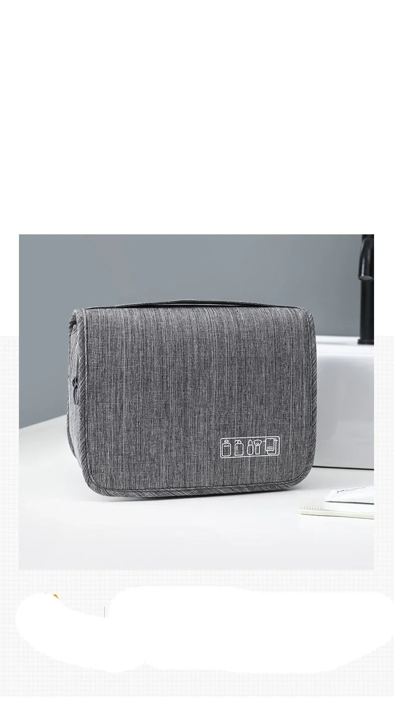Un sac organisateur portable en tissu gris est posé sur une surface blanche.