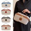 A collection of beige and brown travel toiletry bags with gold accents shown against a dark shirt.