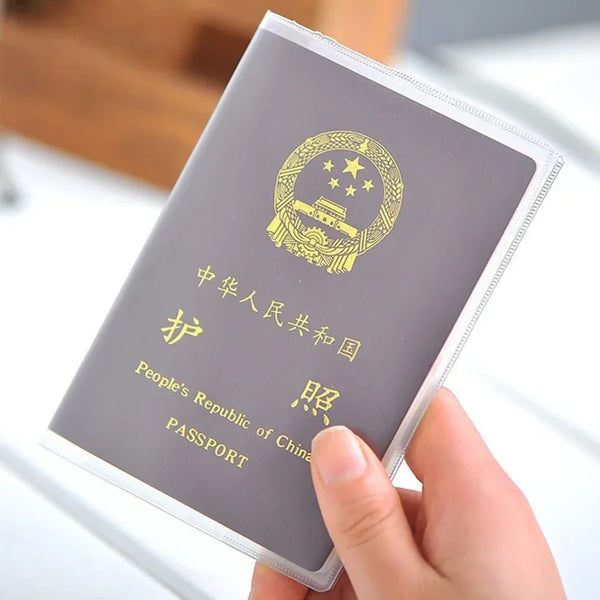 A hand holds a passport with Chinese text and an emblem, showing the inside of a clear card sleeve.