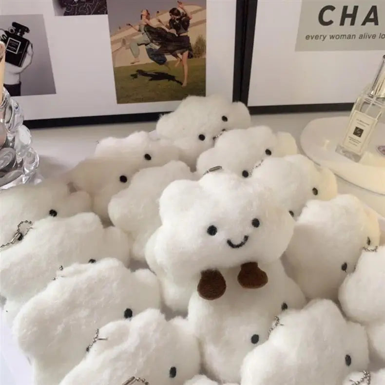 A collection of white, fluffy cloud-shaped plush toys used as pendants or keychains.