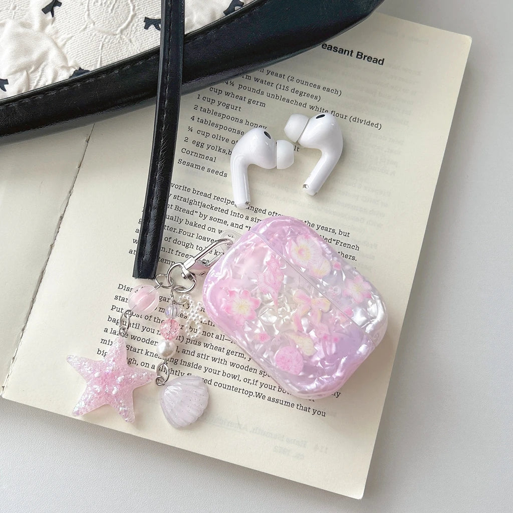 Étui d'écouteurs avec nœud floral rose pour AirPods posé sur une carte de recette.