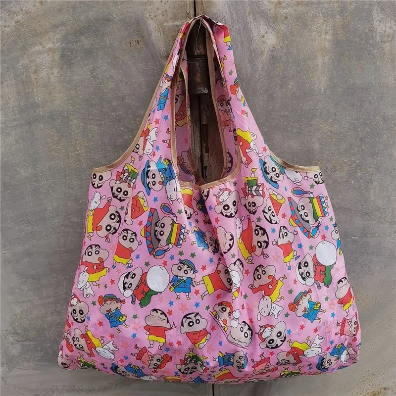 A pink reusable shopping bag with a colorful pattern featuring cartoon animals and faces.