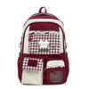 A maroon and white checkered backpack with lace trim and a cat design on the front pocket.