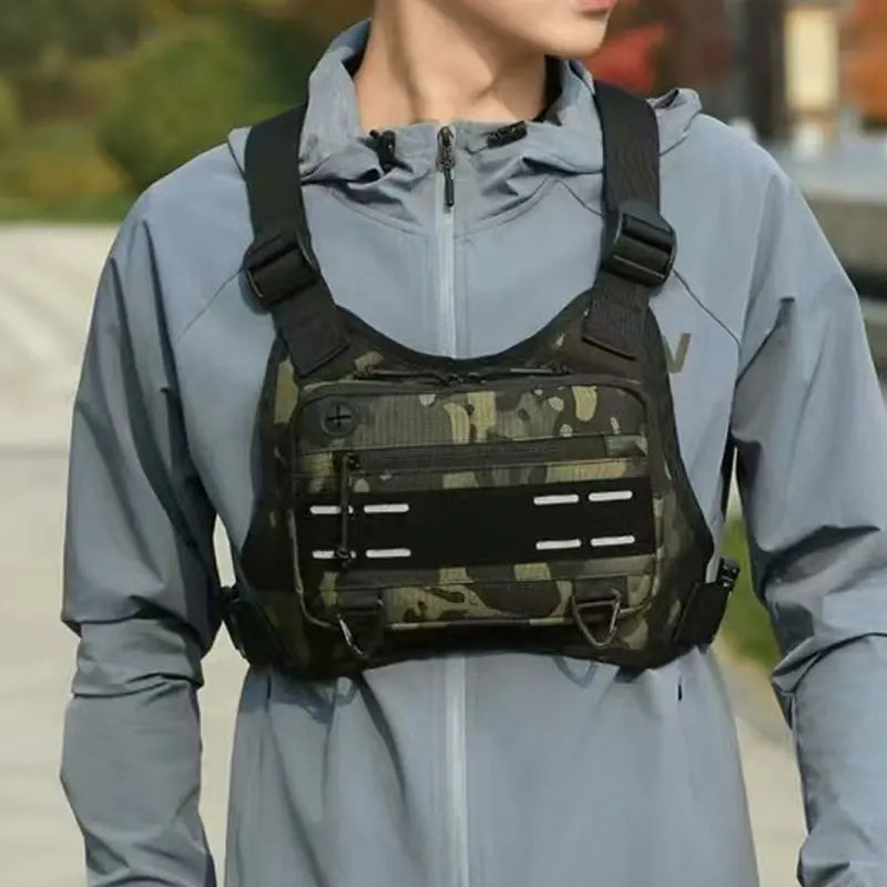A man wearing a light blue jacket with a black tactical chest rig vest bag for outdoor gear.