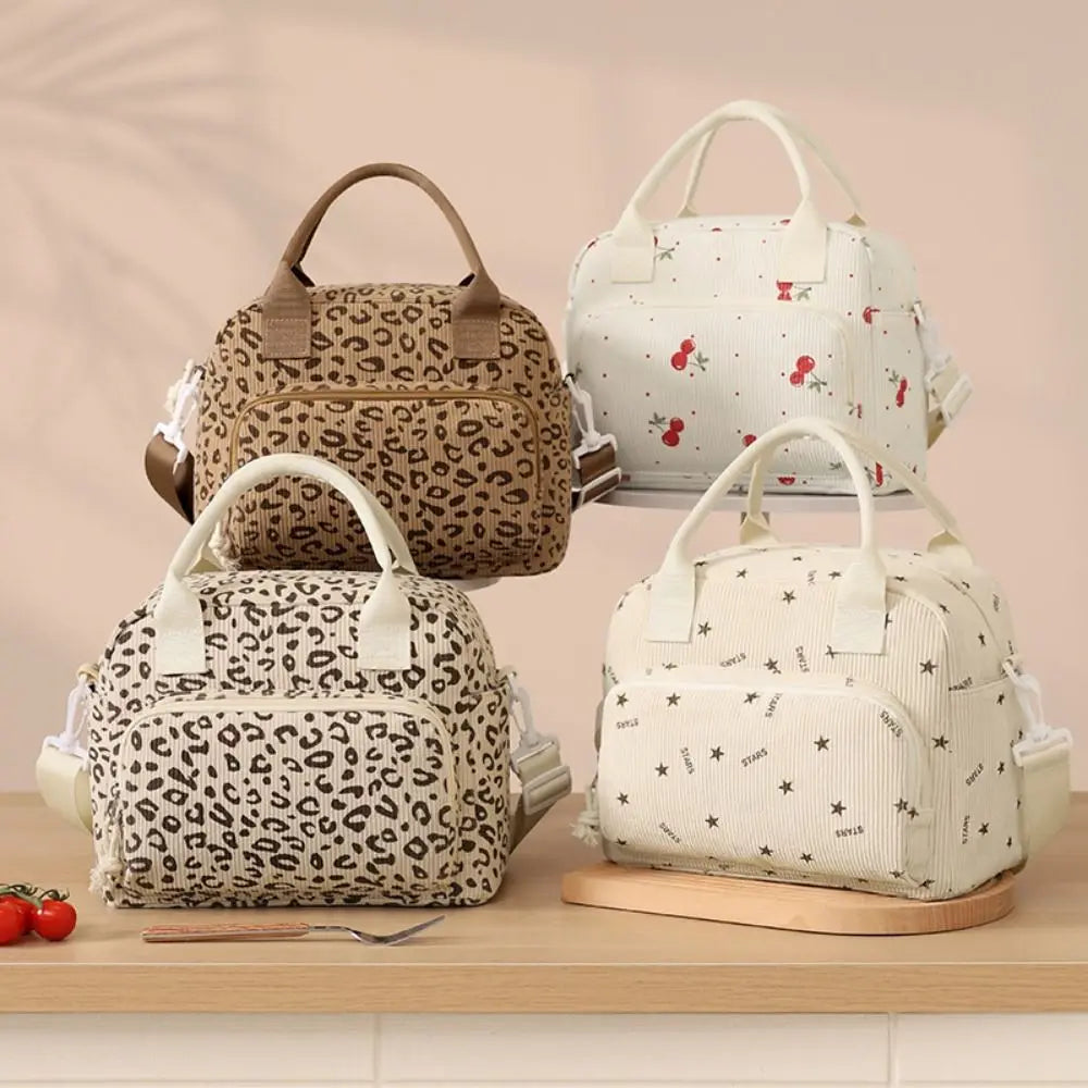 Trois sacs de pique-nique portables à rayures crème et marron en velours côtelé, exposés sur une surface en bois.