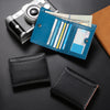 A black carbon fiber RFID-blocking bi-fold wallet is shown next to a camera and some cash.
