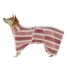 Un chien portant un peignoir de bain rose et blanc rayé et à séchage rapide.