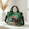 Dunkelgrüne Tasche mit Blumenkatt-Muster und schwarzem Trageriem, auf weißem Untergrund.