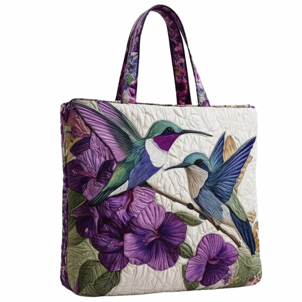 Bolso de tela acolchado vintage con estampado floral morado y verde sobre fondo blanco.