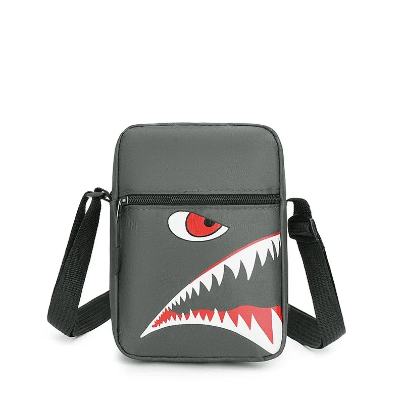 Pochette de téléphone grise en bandoulière avec un motif de dent féroce stylisé sur le devant.