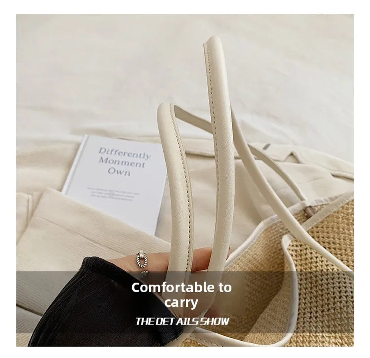 A close-up of a beige straw woven tote bag with light leather trim and matching carrying straps.