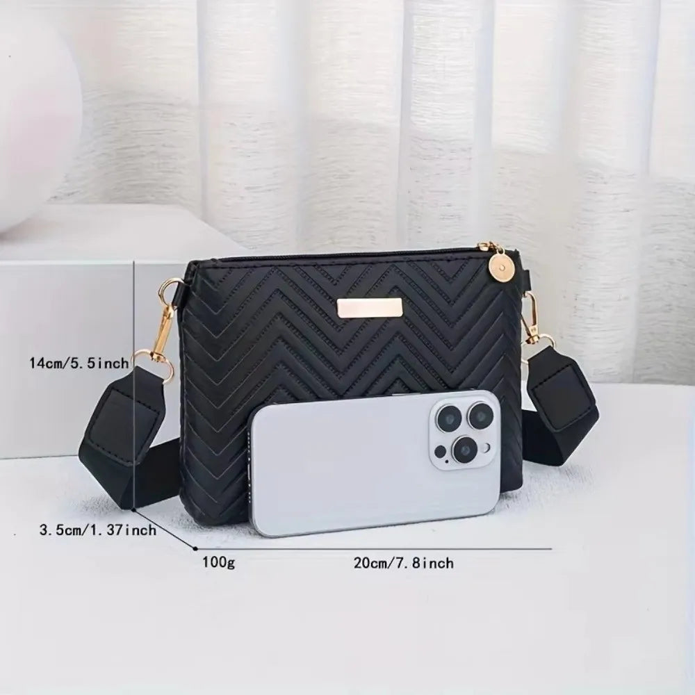 Black quilted minimalist crossbody bag with gold hardware and a white smartphone inside