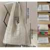 A white knitted shoulder bag displayed next to various size samples and measurements.
