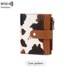 A brown and white cow pattern wallet with a leather cover and zipper.