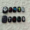 A set of 10 black acrylic press-on nails featuring various designs including a skull, stars, arrows, and spiritual symbols.