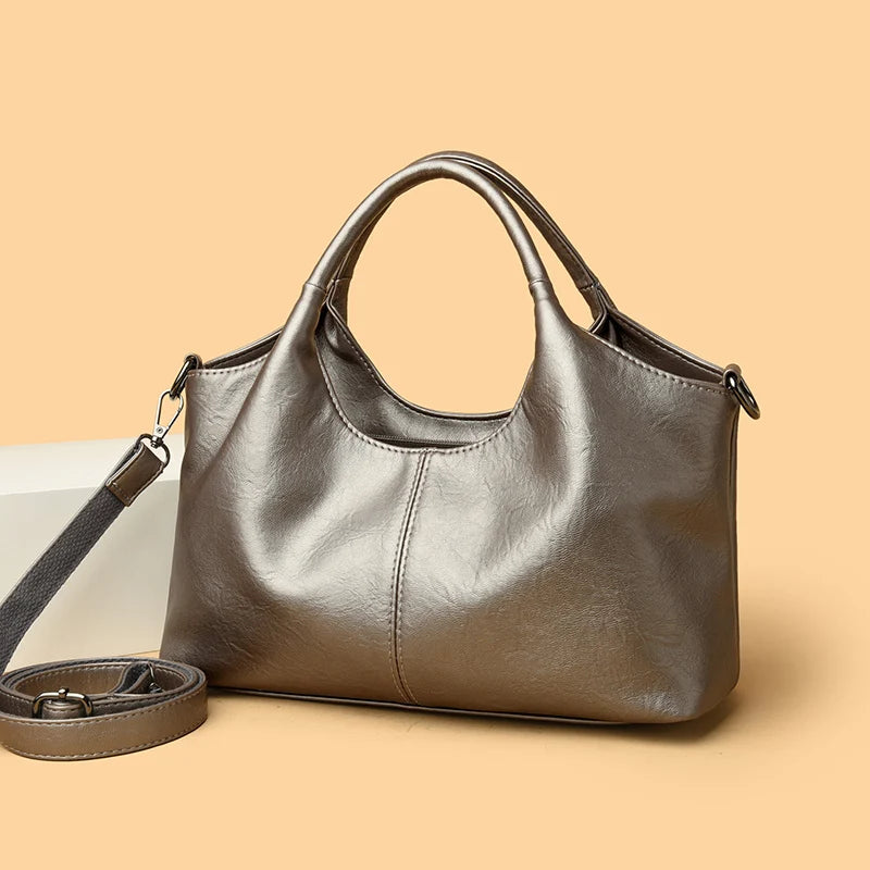 A brown leather casual crossbody shoulder bag with a zip closure resting on a light surface.