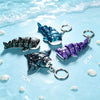 A blue and purple ocean star starry sky devil ray figurine with silver rings displayed on a light blue background.
