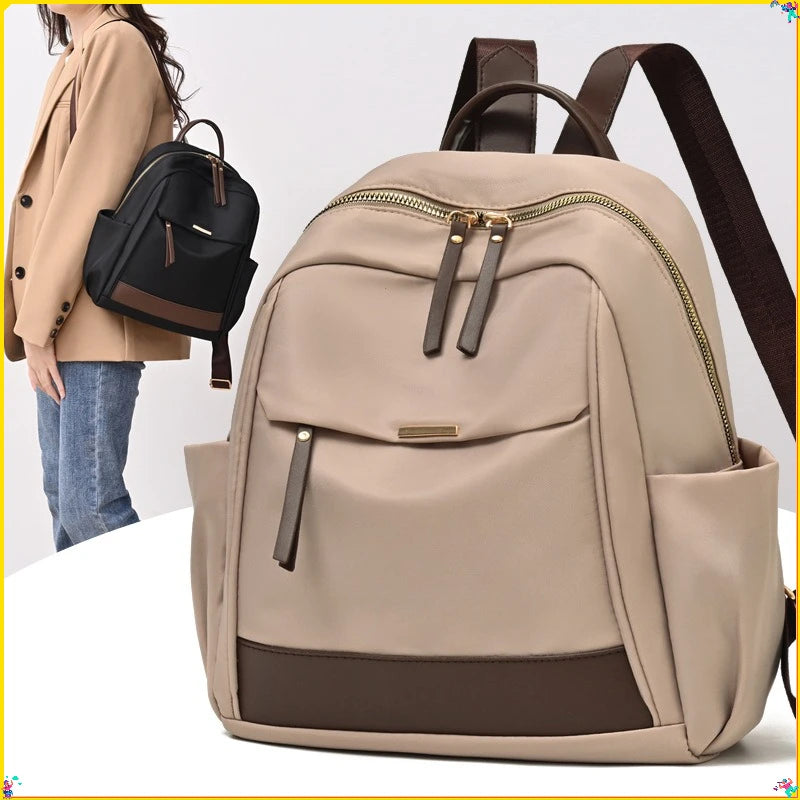 A beige nylon travel backpack with brown accents is shown against a white background.