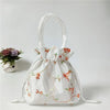 Clutch de noche con lazo de purpurina blanca y bordado floral